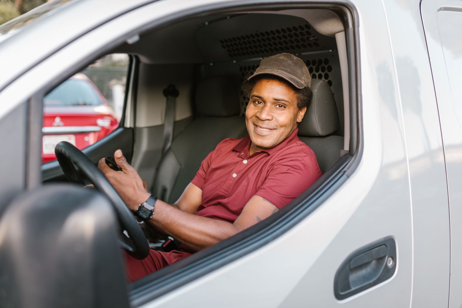 Smiling Globion courier at the wheel of a delivery van