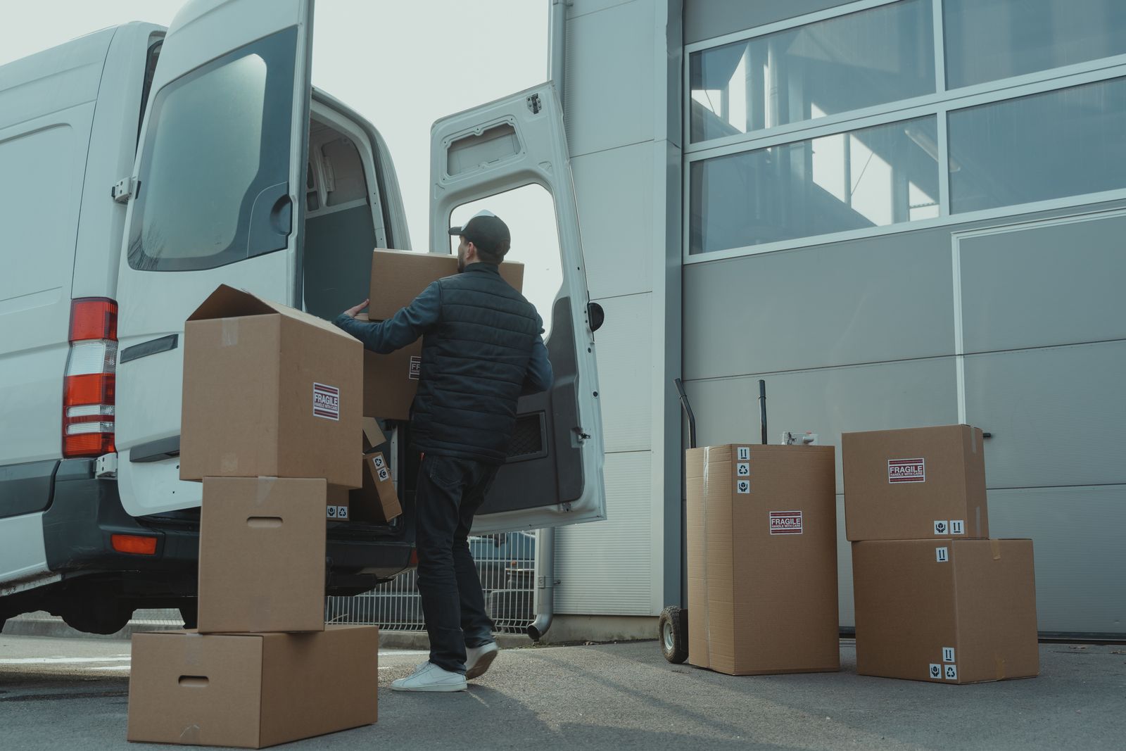 Globion courier loading fragile-labelled boxes into a van
