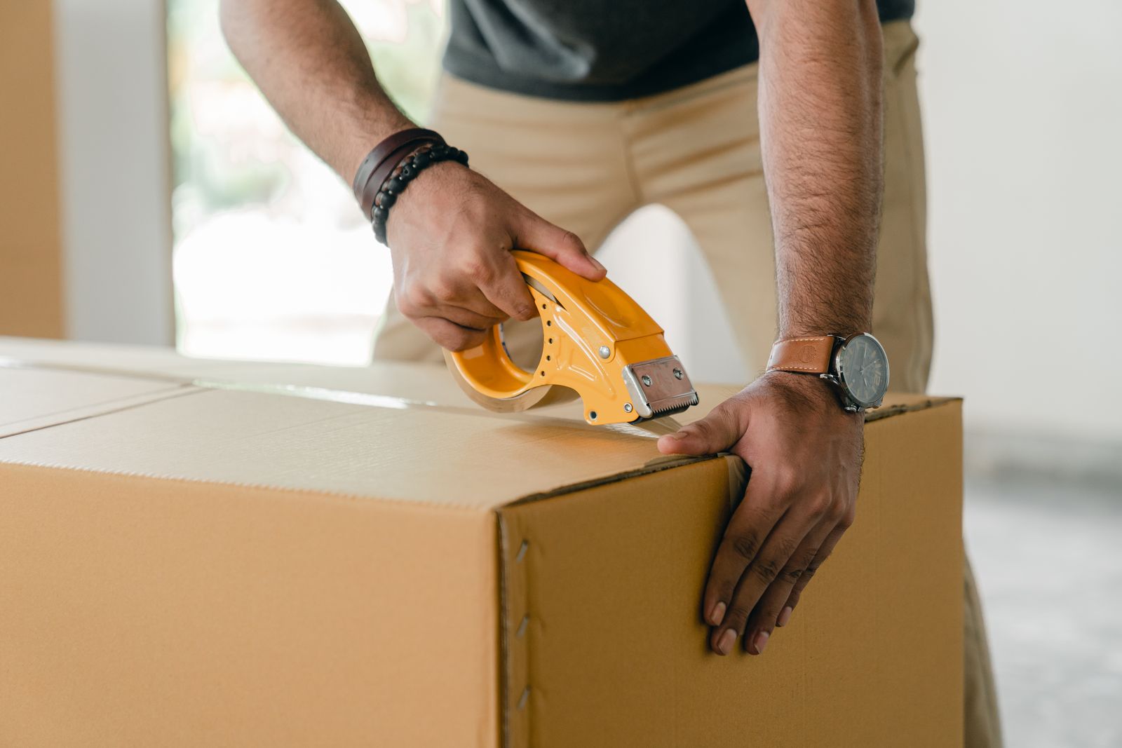 Warehouse operator sealing a carton with a tape gun